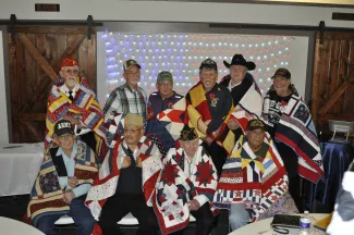 Group of veterans wearing quilts.