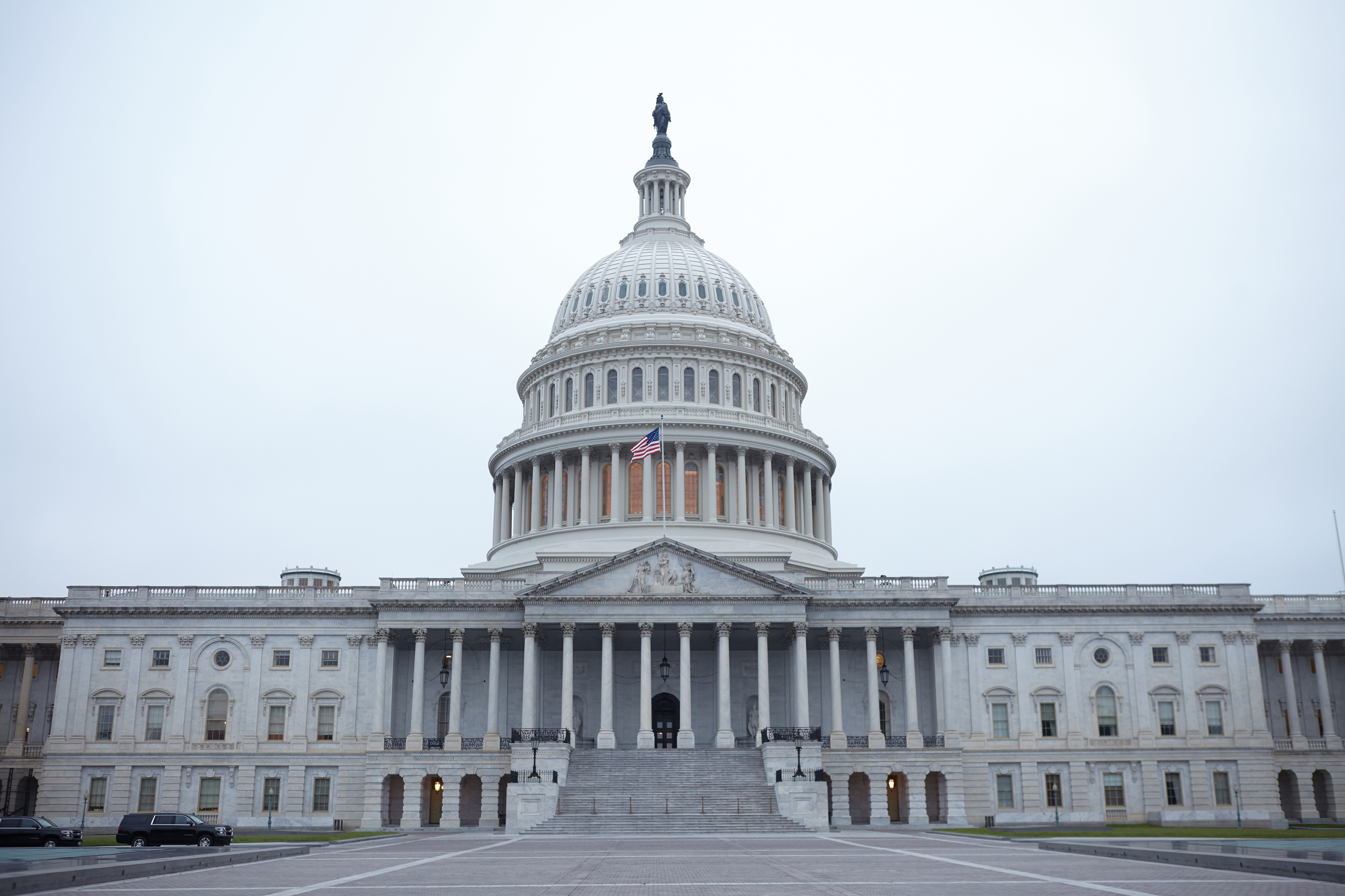 View of the west front door of the United States capitol building under cloudy skies