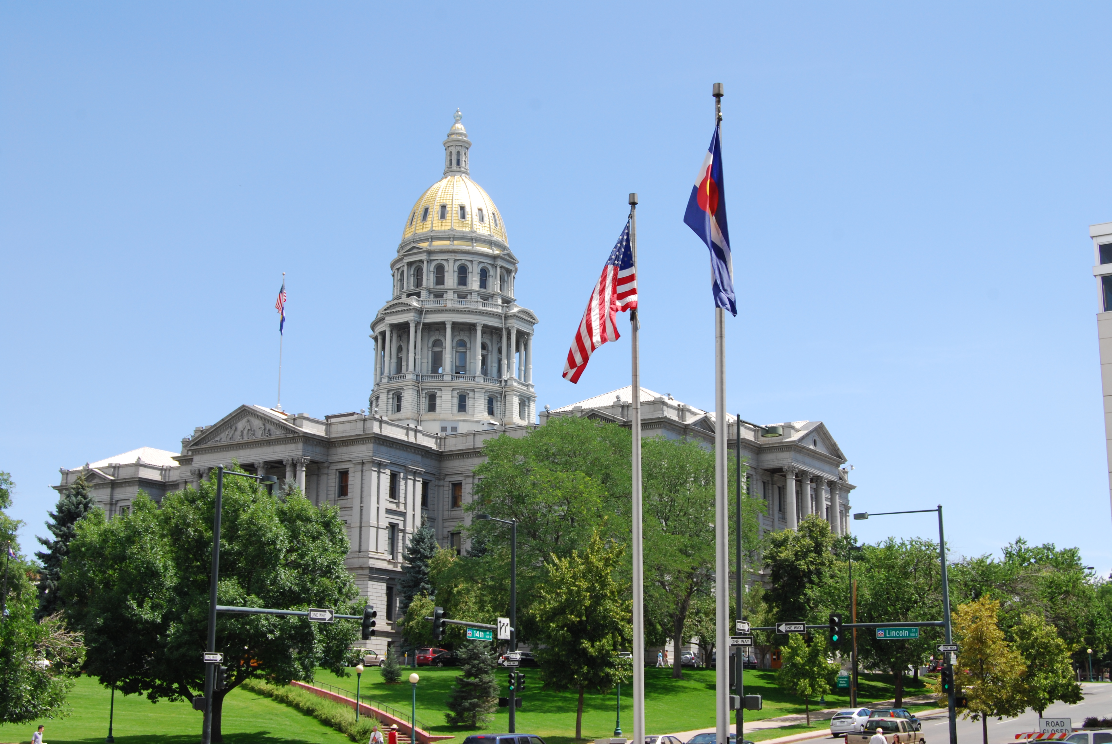 Summer view of the Colorado state capitol building with the United States and Colorado flags