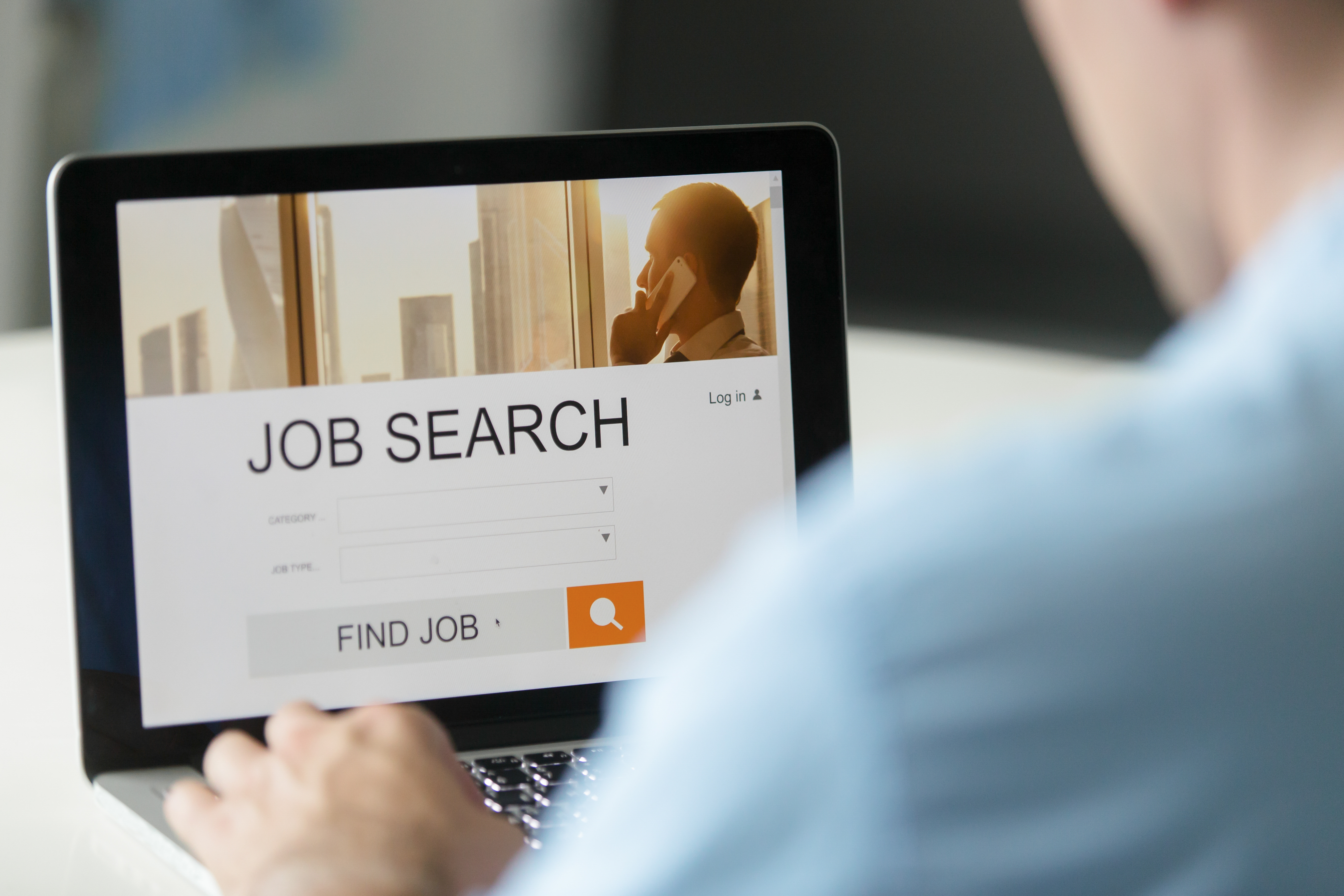 Person sitting at a laptop computer with a screen titled "Job Search"