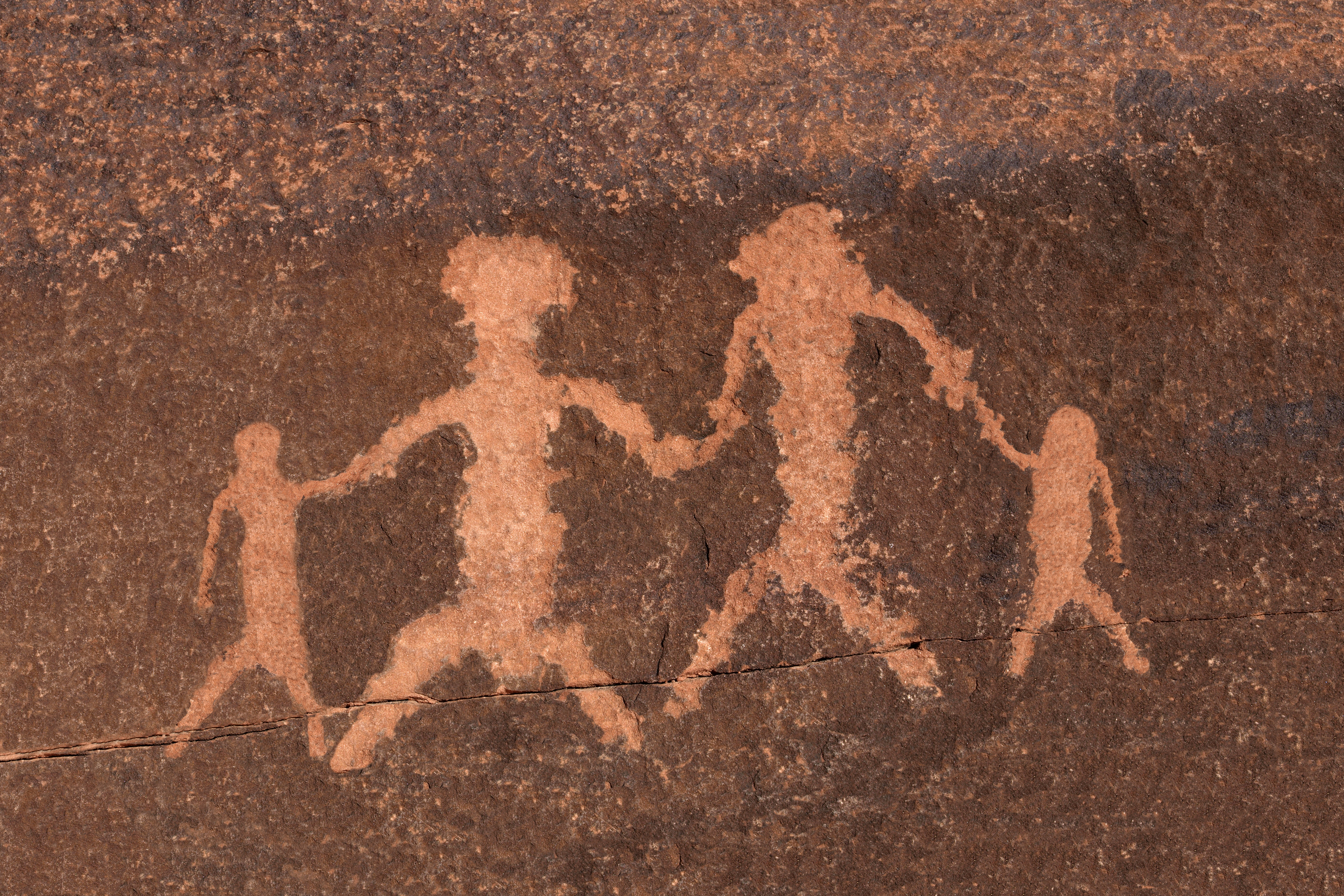 Rock petroglyph representing two adults and two children holding hands