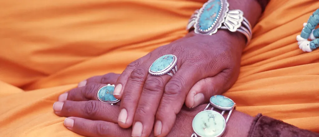 Navajo weaver's hands with turquoise jewelry - Rebecca J Becker - iStock-1251580456