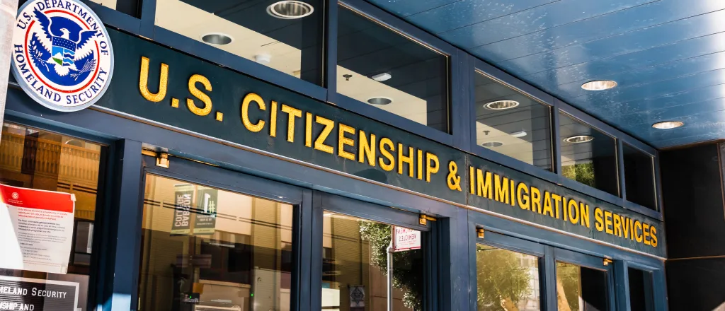 Doors to a building below a sign reading "US Citizenship and Immigration Services"