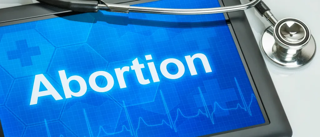 Computer tablet displaying the word "Abortion" with a stethoscope draped over the corner