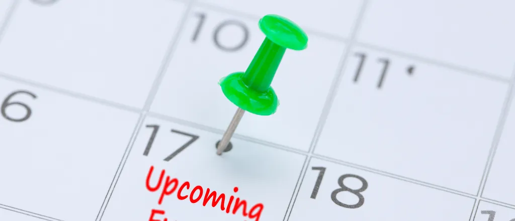 Closeup of a calendar with a pushpin in a date with the words "Upcoming Events"
