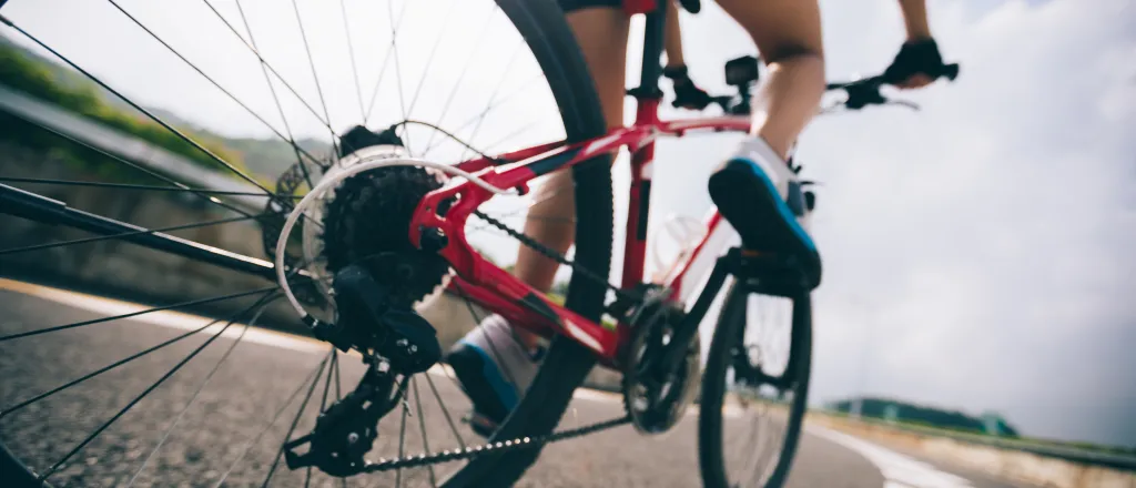 Low angle view of a bicycle with rider traveling on a paved surface