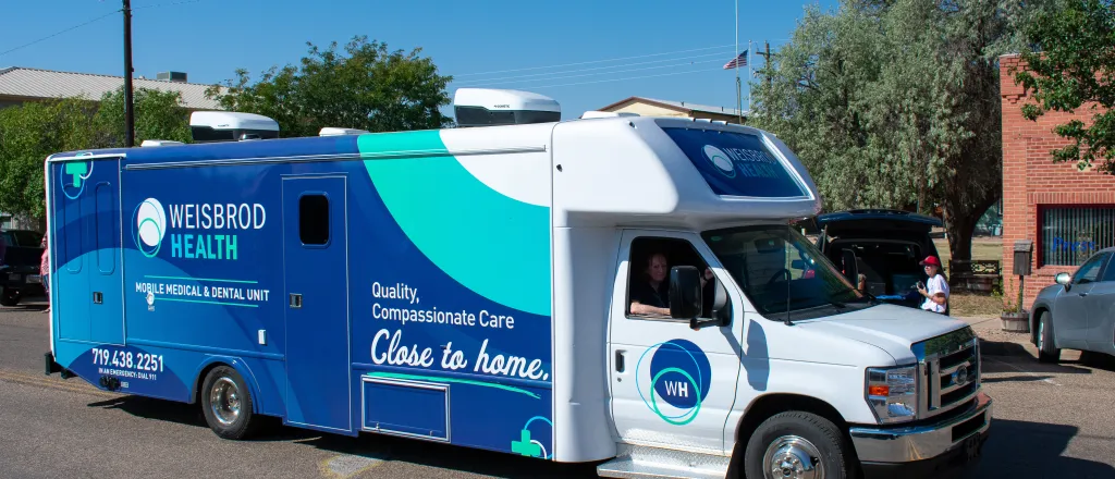 Mobile health and dental vehicle being driven down a street in a rural town.