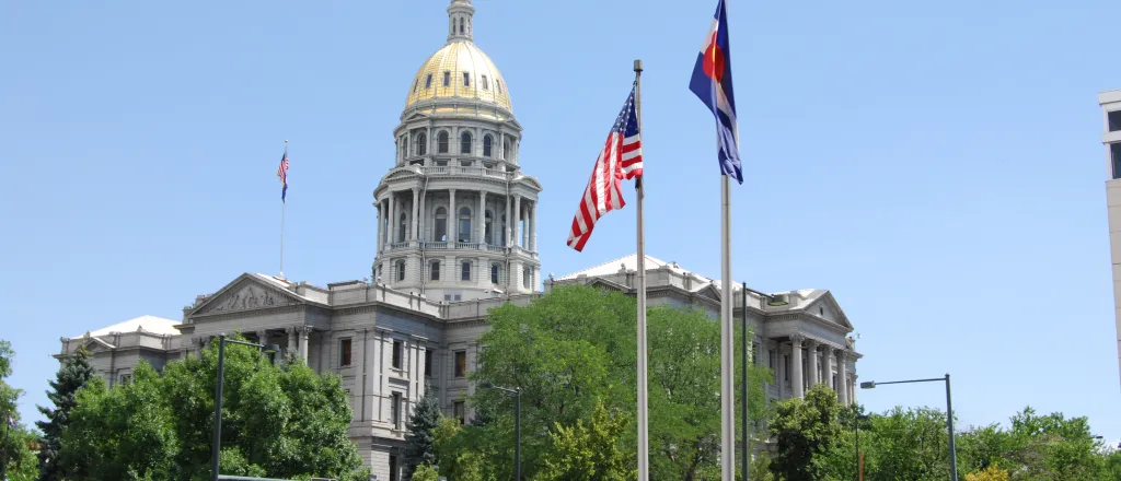 Summer view of the Colorado state capitol building with the United States and Colorado flags
