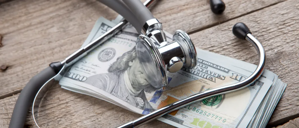 Stethoscope on a stack of paper money