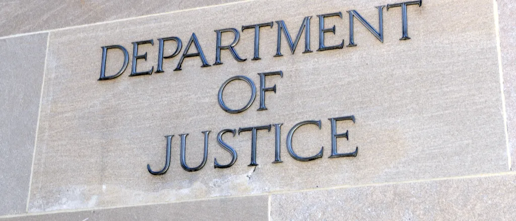 Sign on the side of a building reading "Department of Justice"