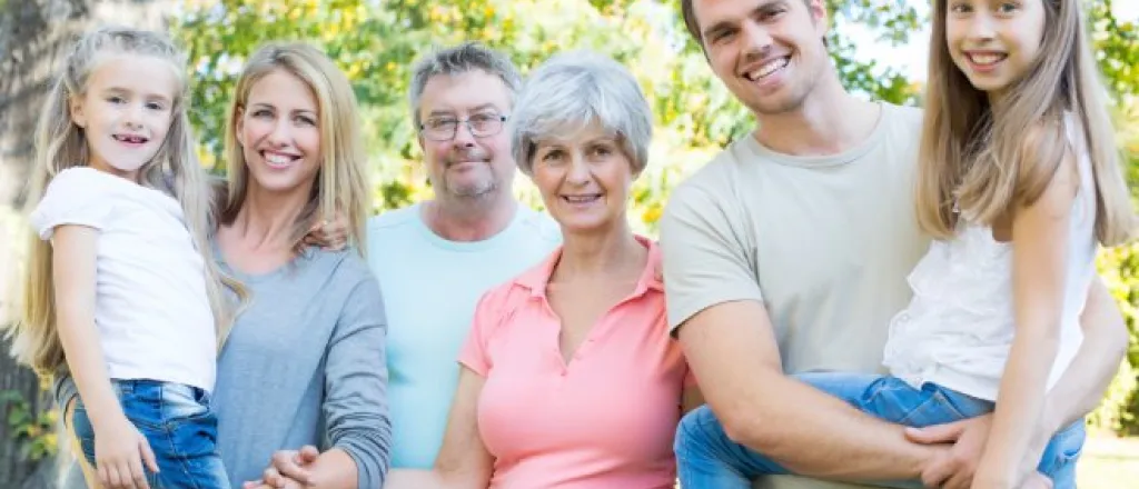 A group of six family members, including a husband and wife, two children, and two grandparents, pose together in a photo.