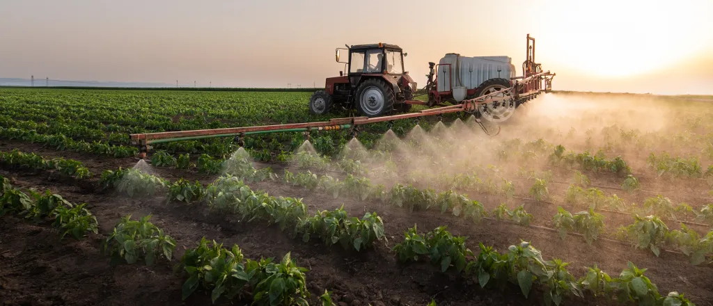 Agricultural spray rig spreading a liquid chemical on a field.