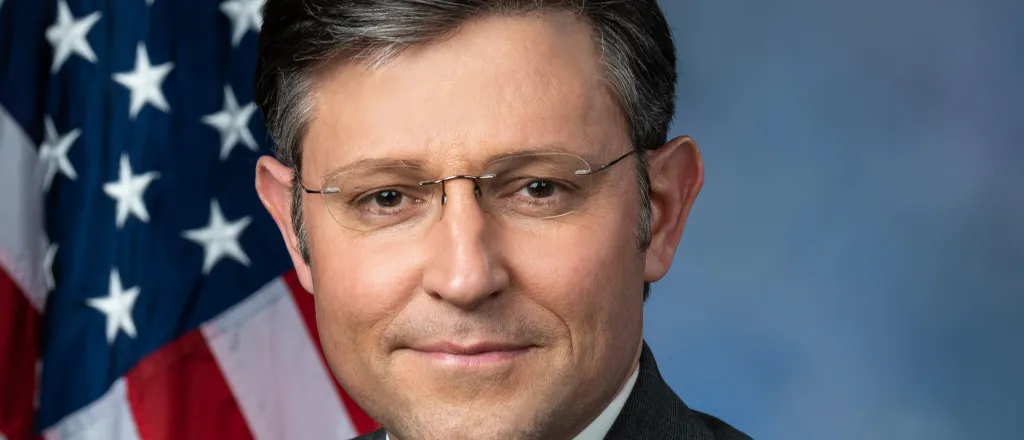 Head photo of politician Mike Johnson. A United States flag is in the background.