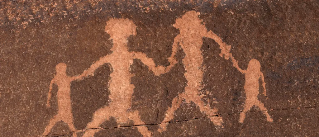 Rock petroglyph representing two adults and two children holding hands