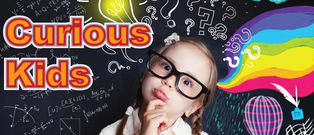 Child wearing glass with head tilted in an inquisitive pose in front of a chalkboard with colorful images