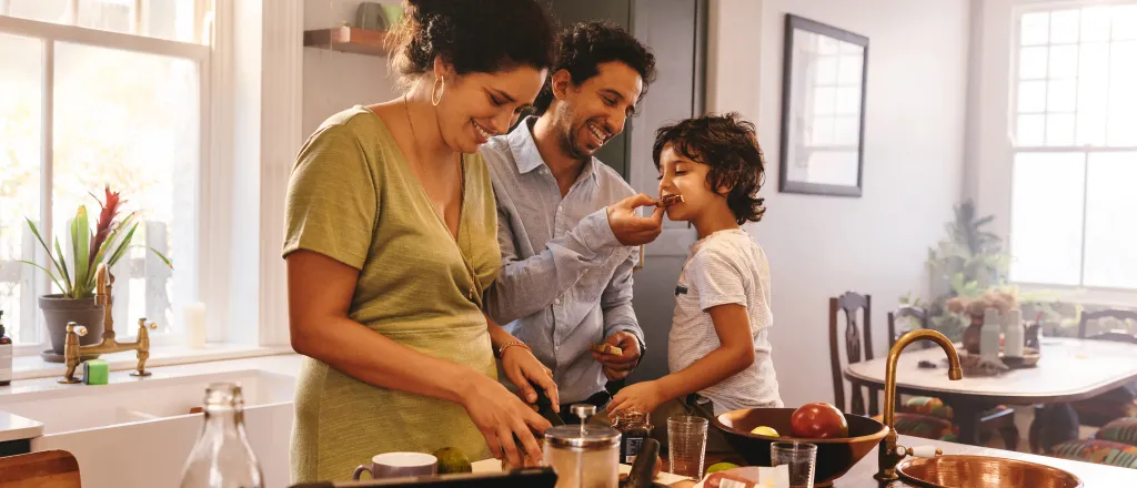 Family cooking in a home kitchen surrounded by ingredients.