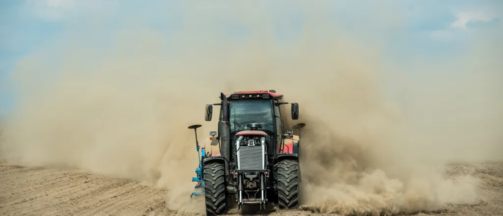 PROMO HIRES Agriculture - Tractor Plow Dust Field Drought - iStock - Dmytro Shestakov Farm tractor driving through bare dirt creating a dust cloud.