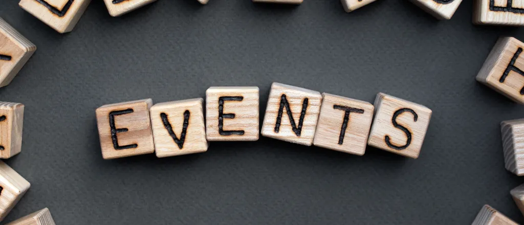 PROMO HIRES Community - Words Events Blocks Living - iStock - Roman Didkivskyi Assorted wooden block with letters on the sides, surrounding the word "events" on wooden blocks