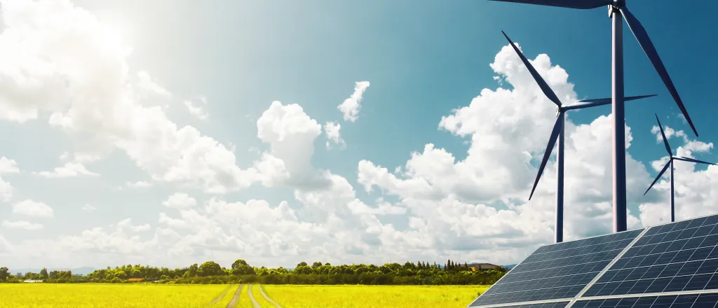 PROMO HIRES Energy - Solar Panel Wind Turbine Field Agriculture Farm - iStock - undefined underfined Solar panels and wind turbines near a vehicle path crossing a field