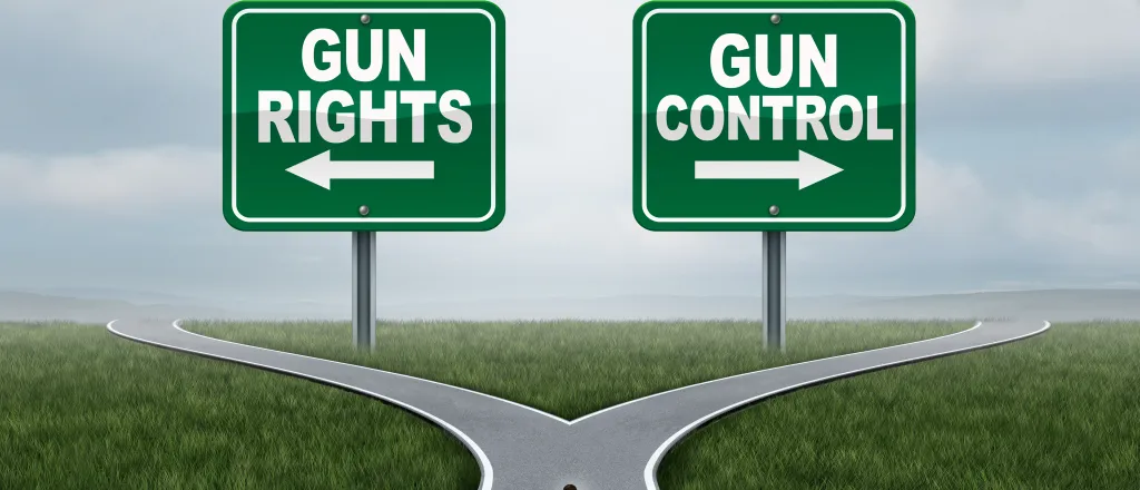 PROMO HIRES Government - Sign Gun Rights Control - iStock - wildpixel Illustration of a person on a road with diverging paths. Two signs are on the horizon. On the left is a sign with an arrow pointing left reading "gun rights." On the right is a sign with an arrow pointing right reading "gun control."