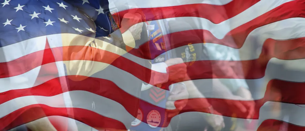 PROMO HIRES Miscellaneous - Flag Veterans People - iStock - flySnow Flag of the United States with images of veterans faded into the lower background.