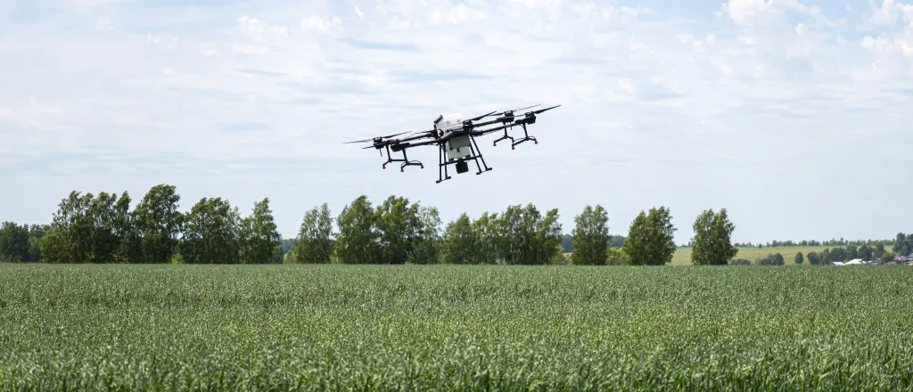 PROMO HIRES Technology - Transportation Miscellaneous Drone UAV Agriculture - Diy13 -iStock-1583942713 An unmanned aerial vehicle- also know as a UAV or drone - hovers or flies over an agricultural crop. Trees are in the background.