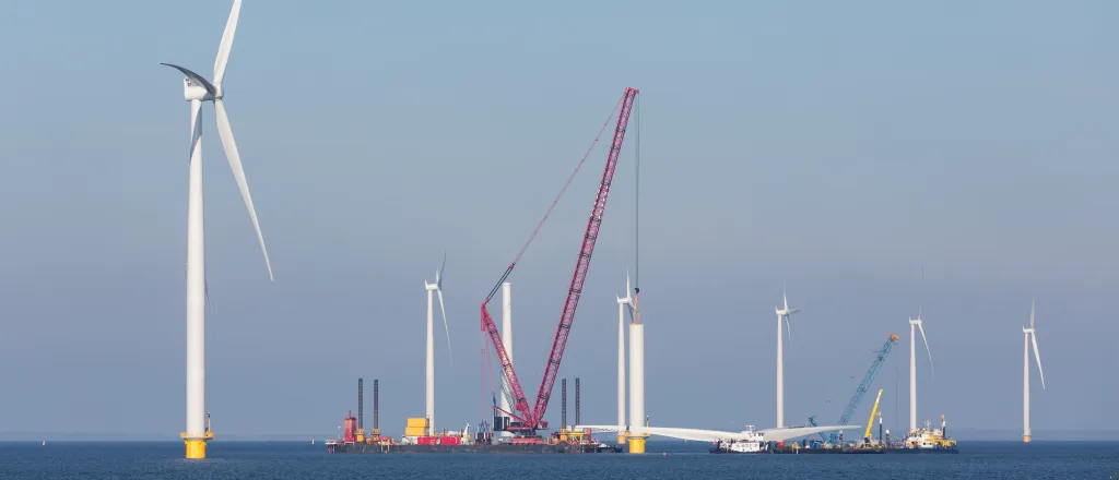 PROMO HIRES Energy - Wind Ocean Offshort Construction Turbine - imaginima - iStock-513672220 Wind turbines under construction in the ocean. A crane ship is in place to lift a blade assembly.