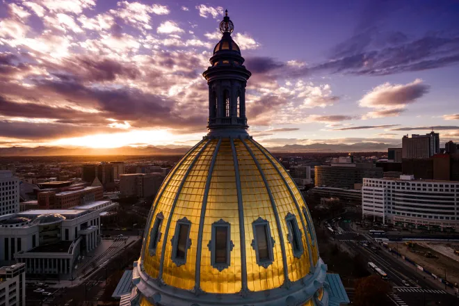 Aerial view of the Colorado capitol building dome with clouds at sunset.