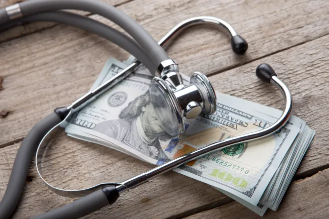 Stethoscope on a stack of paper money