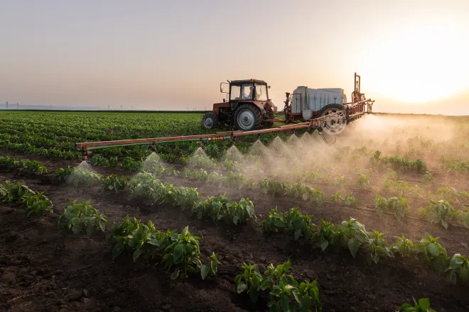 Agricultural spray rig spreading a liquid chemical on a field.