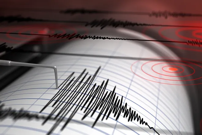 Earthquake seismograph drum with a stylus pen recording a large disturbance.