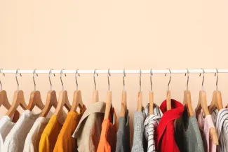 Hanging clothing rack with hangers, shirts, and jackets.