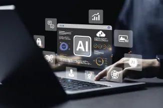 Hands on a computer keyboard with simulated holographic images floating above representing aspects of artificial intelligence