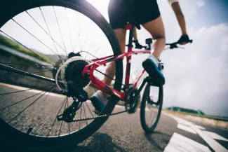 Low angle view of a bicycle with rider traveling on a paved surface