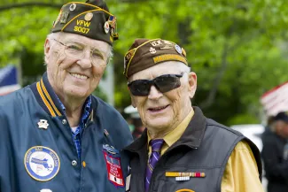 Two United States military veterans wearing medals and uniform hats - flySnow - iStock-507449191