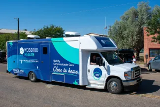 Mobile health and dental vehicle being driven down a street in a rural town.