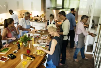 Numerous people in a large kitchen performing various cooking duties.