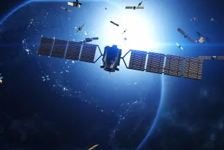 PROMO HIRES CROPPED Communication - Satellite Earth Space Globe - yucelyilmaz - iStock-2101393672 Concept image of satellites in orbit around a planet. A large satellite is in the foreground.