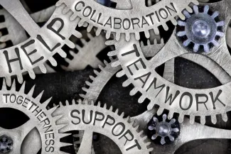 PROMO HIRES Community - Gears Words Help Collaboration Teamwork Support Togetherness - iStock - EtiAmmos Interlocking machinery gears with the words "help, collaboration, teamwork, support, and togetherness" stamped on the side
