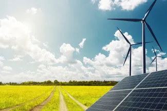 PROMO HIRES Energy - Solar Panel Wind Turbine Field Agriculture Farm - iStock - undefined underfined Solar panels and wind turbines near a vehicle path crossing a field