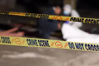Close up of crime scene tape, which has the words "Do not cross," "No entry," and "Crime scene" printed in a repeating pattern.