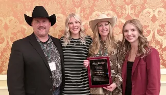 People posing for a photo with an award plaque
