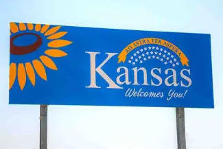 PROMO States - Kansas Welcome Sign Sunflower Sky - iStock - AndreyKrav