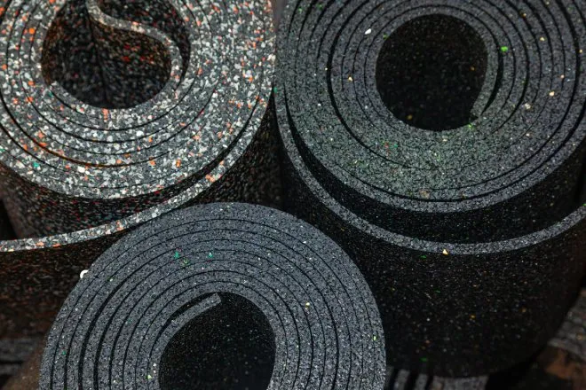 Three large rolls of treated composite rubber of slightly different colors. The view is from the top down.