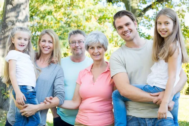 A group of six family members, including a husband and wife, two children, and two grandparents, pose together in a photo.