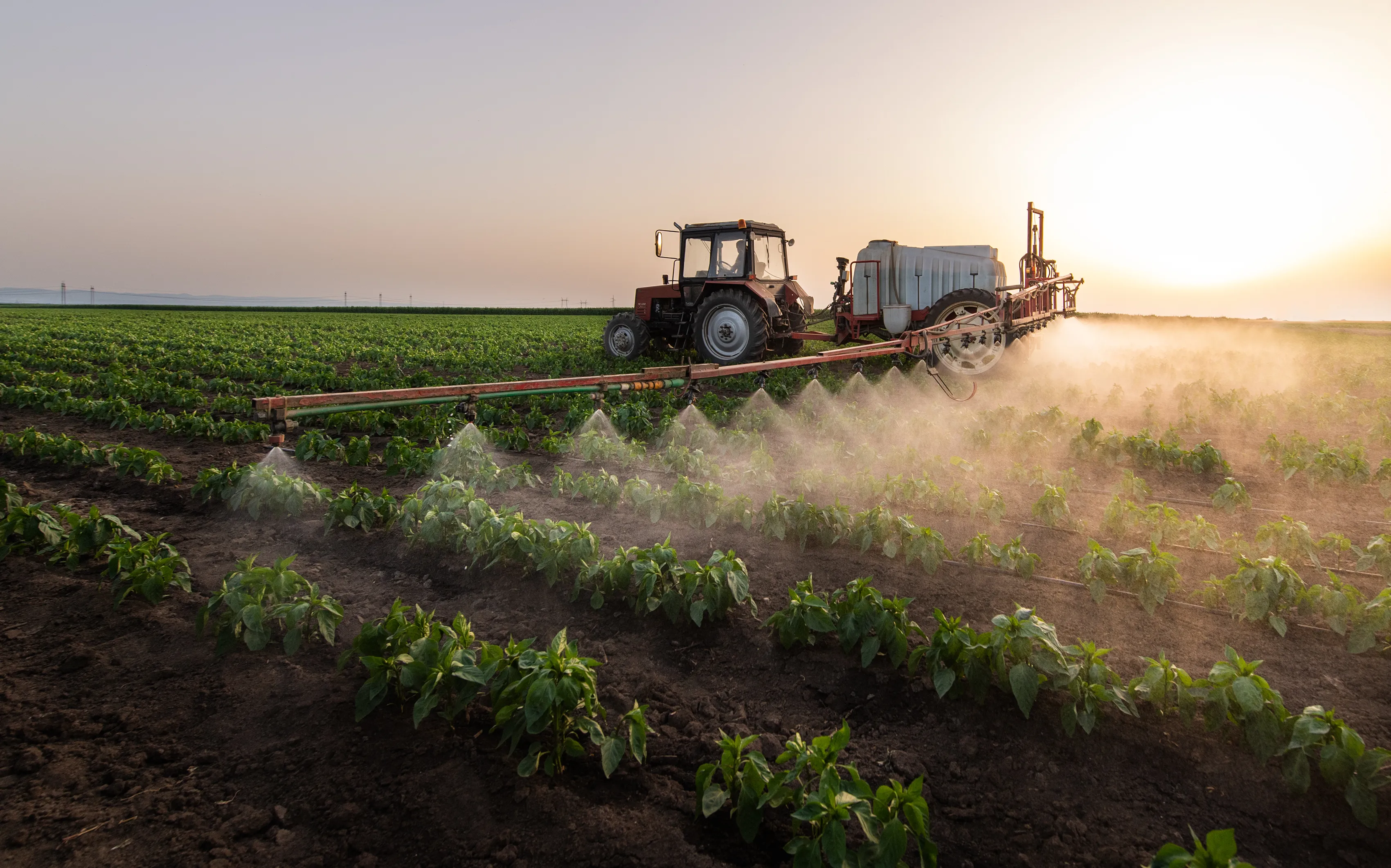 Agricultural spray rig spreading a liquid chemical on a field.