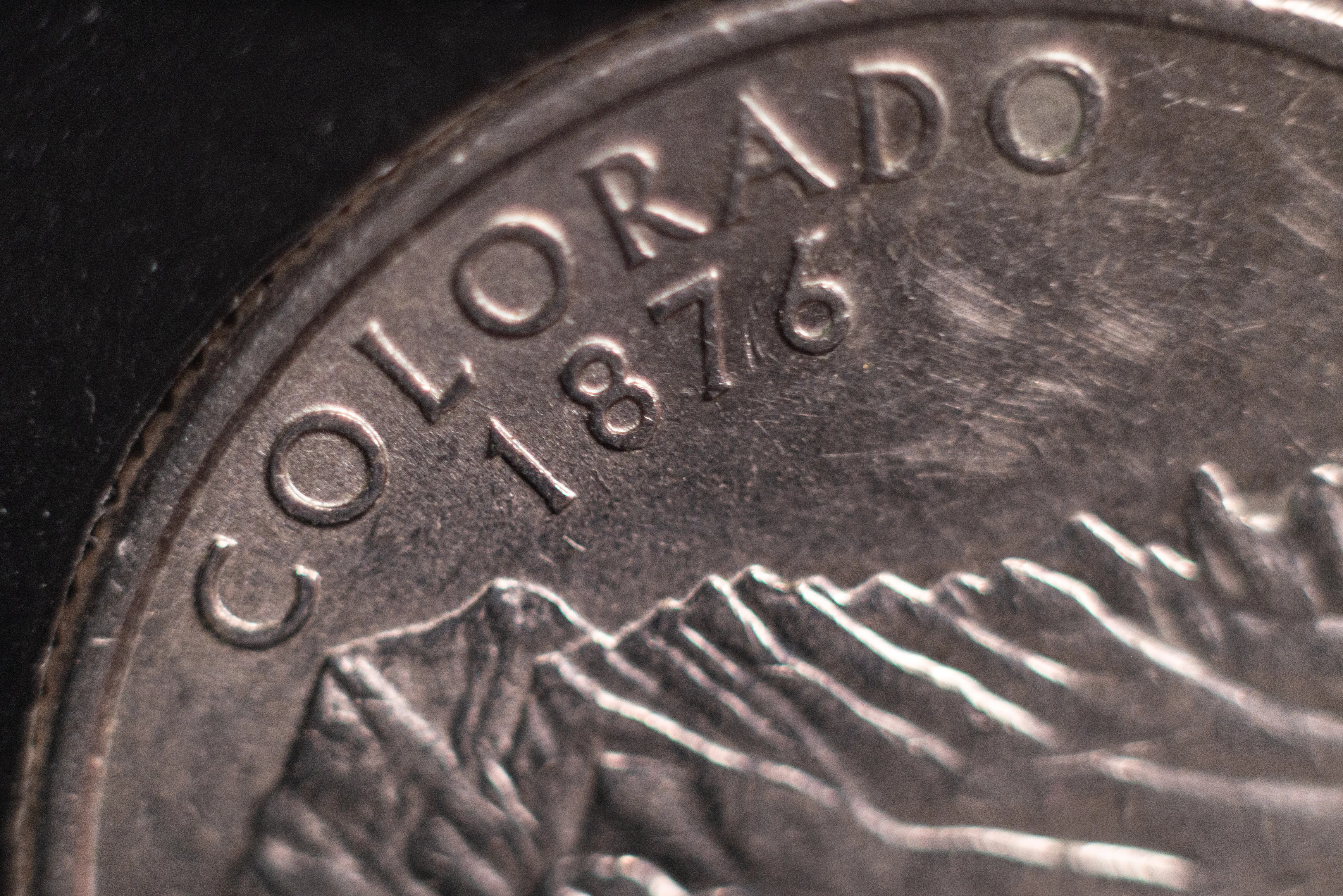 Closeup of a United States quarter coin showing "Colorado 1876"