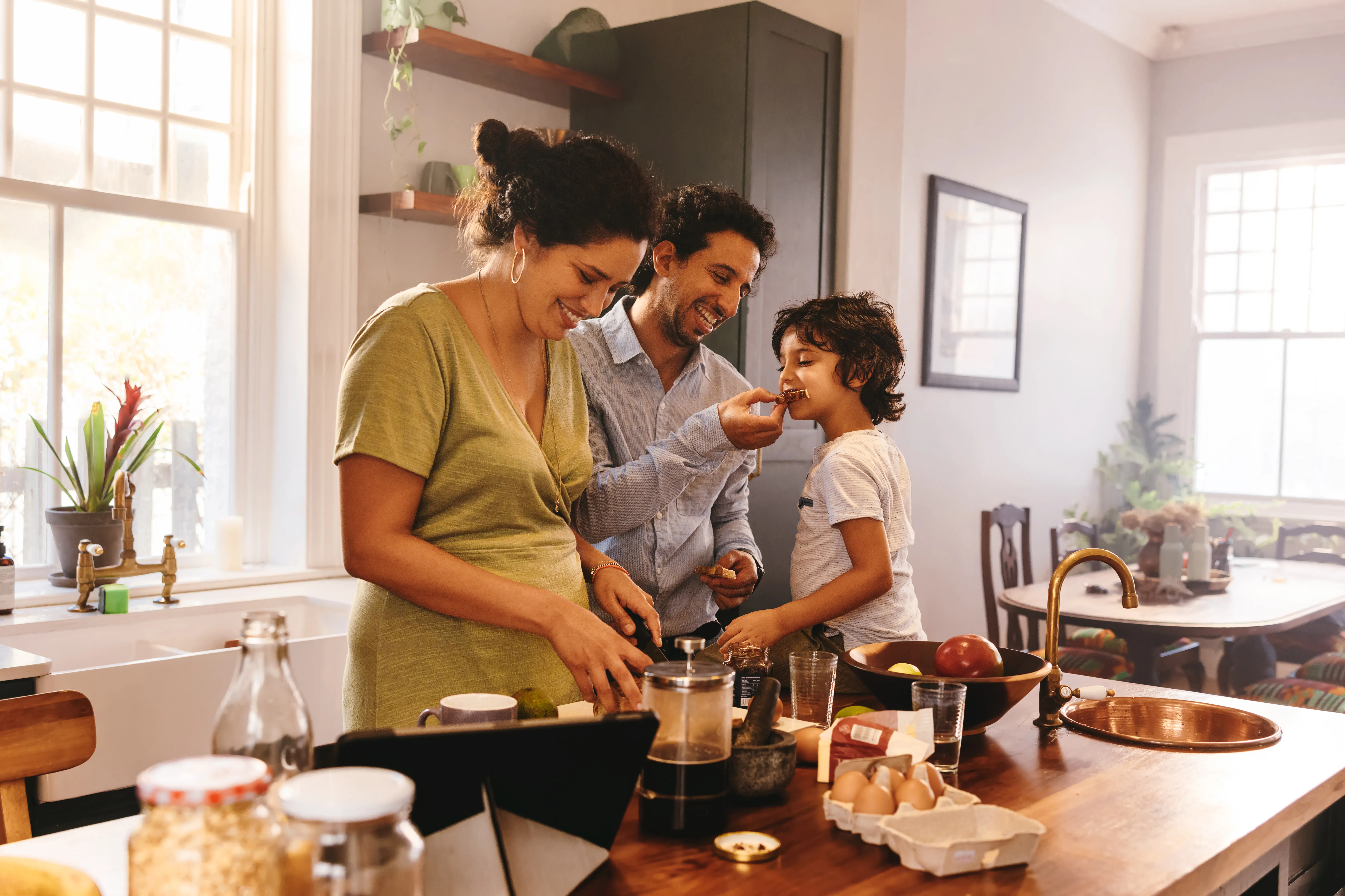 Family cooking in a home kitchen surrounded by ingredients.