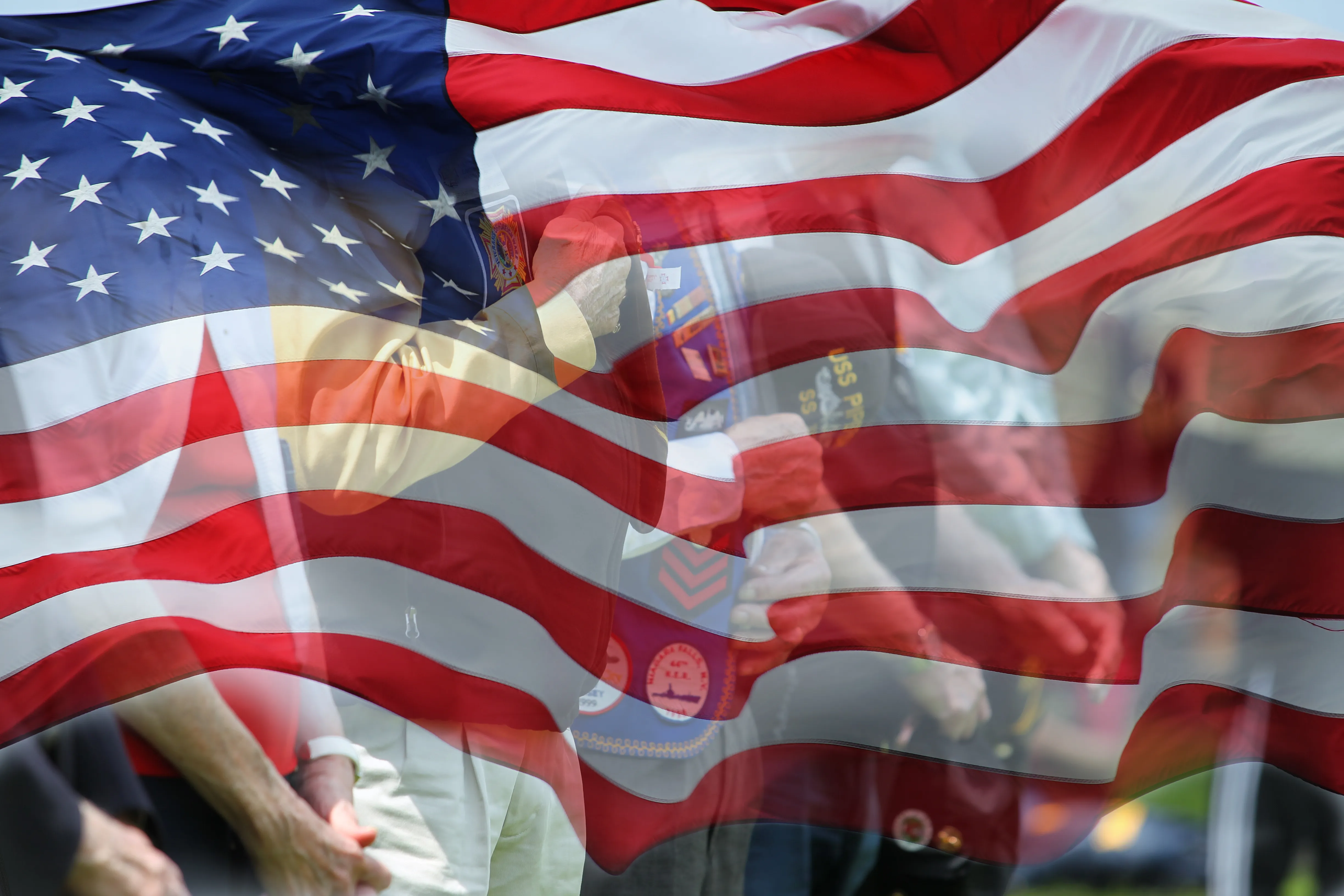 Flag of the United States with images of veterans faded into the lower background.