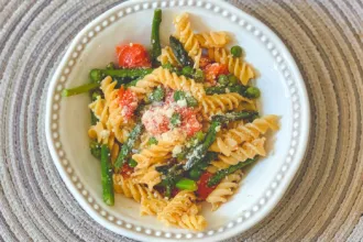 Bowl of Pasta Primavera on a place mat.